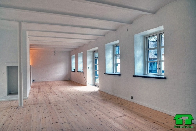 Kombineret tilbygning og renovering af ældre hus med nyt tag på Sjælland